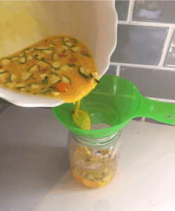 make ahead freezer quiche: egg mixture being poured into mason jar