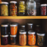 two shelves with a variety of canned foods in jars